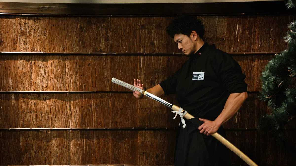 Instructor correcting a student's katana stance during a samurai sword lesson at a museum in Tokyo